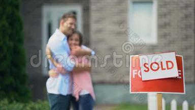 可爱的夫妇拥抱和微笑，庆祝购买伟大的房子，<strong>招牌</strong>